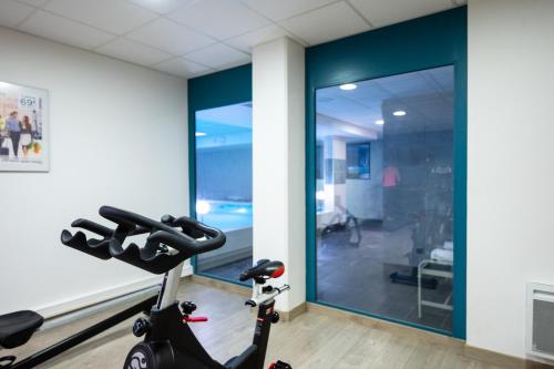 a room with a gym with a exercise bike at Nemea Appart Hotel Quai Victor Tours Centre in Tours