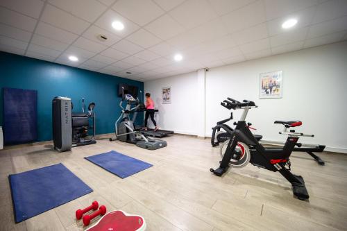 a gym with two treadmills and two exercise bikes at Nemea Appart Hotel Quai Victor Tours Centre in Tours