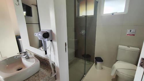 a bathroom with a shower and a sink and a toilet at Essência do Sol Pousada in Florianópolis