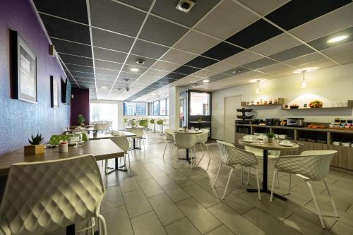 a dining room with tables and chairs in a restaurant at Nemea Appart Hotel Quai Victor Tours Centre in Tours