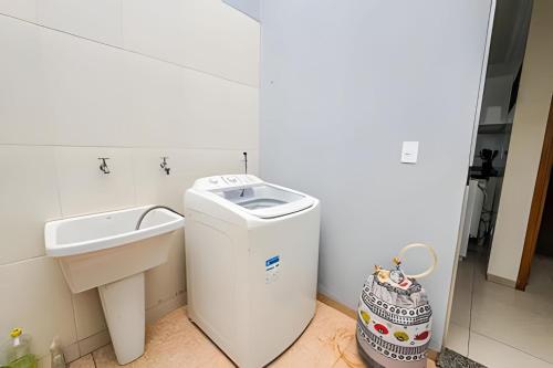 a bathroom with a trash can and a sink at Vila São José 2 in Ourinhos