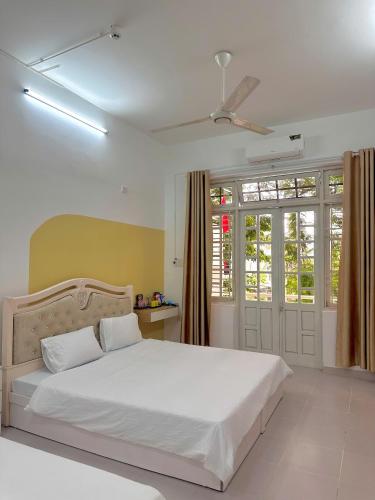 En eller flere senge i et værelse på Color Homestay