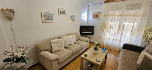 ein Wohnzimmer mit Sofa und Tisch in der Unterkunft Casa Esmeralda Faliro in Athen