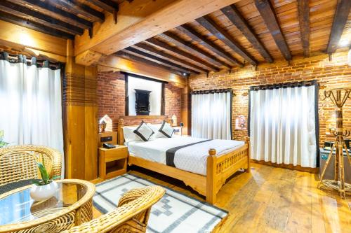 a bedroom with a bed and a table and chairs at Sulimha Durbar in Pātan