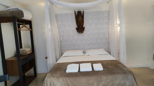 a bedroom with a bed with two white towels on it at Essência do Sol Pousada in Florianópolis