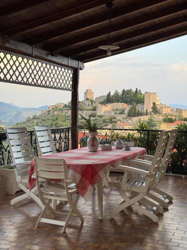 a table with a red table cloth on top of a balcony at Benesié - Villa with castle view in Monte San Giovanni Campano
