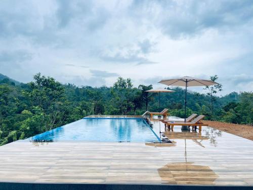 NelluwaにあるRainforest Mount Villaのテーブルとパラソルのあるプール