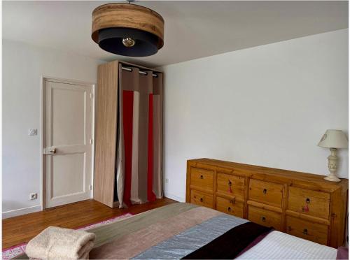 a bedroom with a bed and a wooden dresser at Presbytère du 19e siècle in La Chapelle-du-Bois-des-Faulx