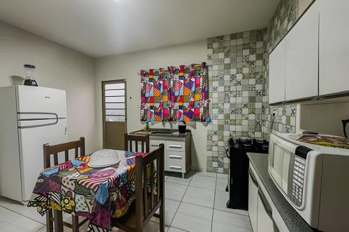 a kitchen with a table and a kitchen with a stove at Jardim Florida 1 in Ourinhos