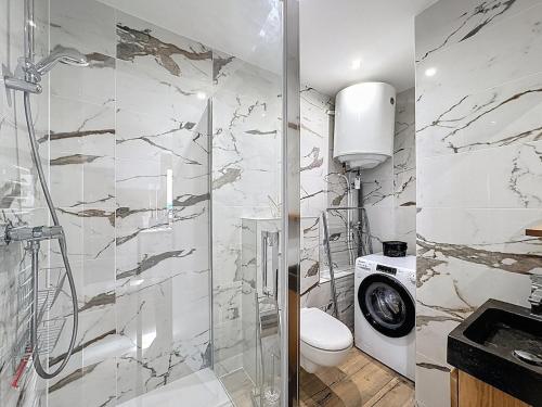 a bathroom with a shower and a toilet and a sink at T2 plein centre avec balcon 5 min gare à pied in Bellegarde-sur-Valserine