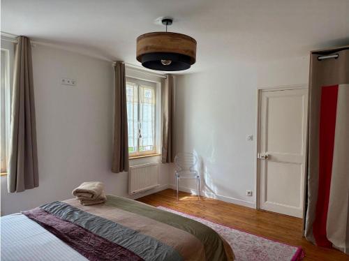 a bedroom with a bed and a window at Presbytère du 19e siècle in La Chapelle-du-Bois-des-Faulx