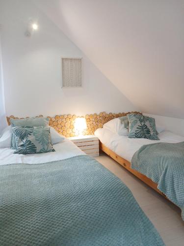 a bedroom with two beds and a lamp on a wall at Eleonor Accommodation in Liszki