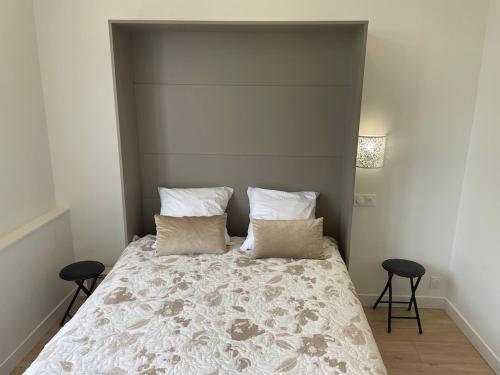 una camera da letto con un grande letto con due sgabelli di Studio dans la résidence Hermitage a Le Touquet-Paris-Plage