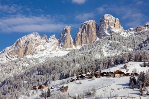 a ski lodge in the mountains in the snow at Hotel Rubino Deluxe in Campitello di Fassa