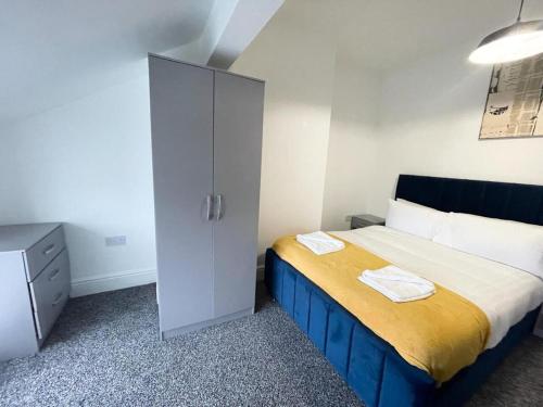 une chambre avec un lit et une armoire avec des serviettes dessus dans l'établissement Stylish Flat 1BR Sofa Bed Walk to Pier & Tower, à Blackpool