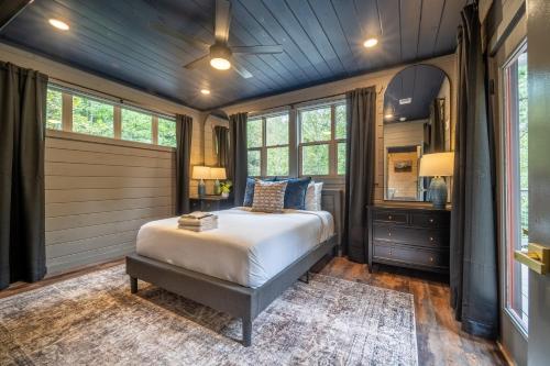 a bedroom with a bed in a room with windows at Multi Level Getaway Pool Hot Tub and Fireplace in Pittman Center