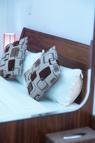 a bed with two pillows on top of it at Le Feto 3 in Dakar