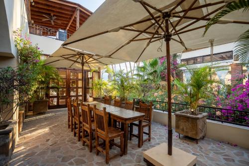 een tafel en stoelen met een parasol op een terras bij Posada de las Flores La Paz in La Paz