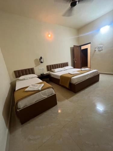a room with two beds and a mirror at The Fero Hotel in Somnath
