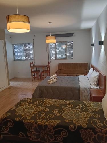 a hotel room with two beds and a table at SOBREIRO - Sobreiro Alojamento - Grijó in Grijó