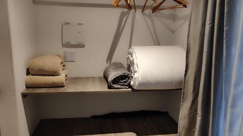 a room with a bed and towels on a shelf at Essência do Sol Pousada in Florianópolis
