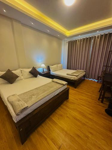 Un dormitorio con dos camas y una mesa y sillas. en VOGUE RESIDENCE - Black Pool, en Nuwara Eliya