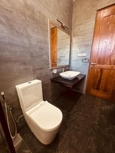 Un baño con un inodoro blanco y un lavabo. en VOGUE RESIDENCE - Black Pool, en Nuwara Eliya