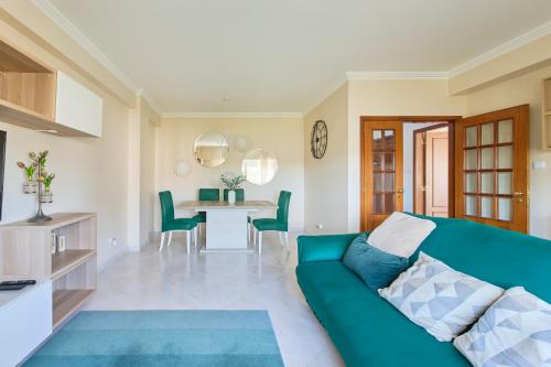 a living room with a green couch and a table at CasaFernandes 15 - Premium stay in Lisbon in Odivelas