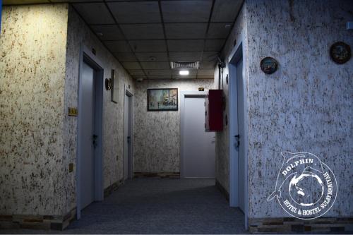 an empty hallway with a door and a sign on the wall at Dolphin Hotel & Hostel in As Sulaymānīyah