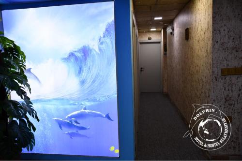 a sign in a hallway with a wave and dolphins in the water at Dolphin Hotel & Hostel in As Sulaymānīyah
