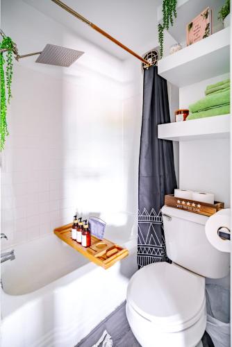 a bathroom with a white toilet and a bath tub at Short North Convention Private Parking Pets in Columbus