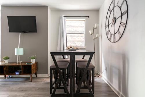 a dining room with a table and a clock on the wall at Short North Convention Private Parking Pets in Columbus