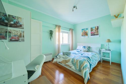 a bedroom with blue walls and a bed and a desk at CasaFernandes 15 - Lisbon near Metro line in Odivelas