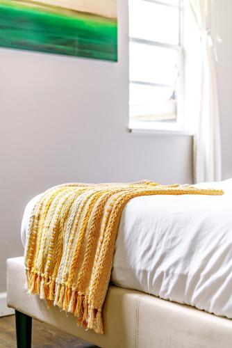 a blanket on the edge of a bed in a bedroom at Short North Convention Private Parking Pets in Columbus