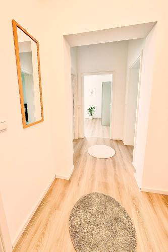 a hallway with white walls and a rug and a mirror at Ideale Stadtwohnung in Siegen Parkplatz WLAN Autobahn in Siegen