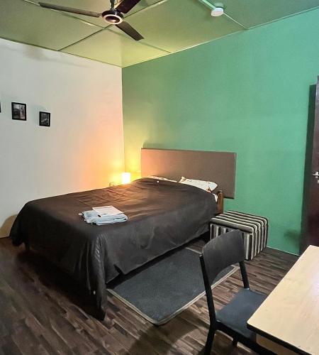 a bedroom with a bed with a green wall at Prime Cottage 2bhk independent cottage home in Dimāpur