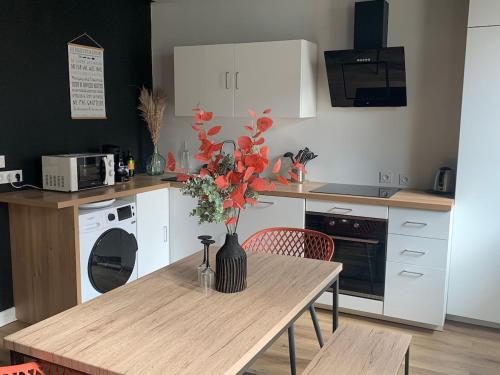 eine Küche mit einem Tisch mit einer Vase mit Blumen darauf in der Unterkunft T3 centre ville 70 m2 avec terrasse in La Baule