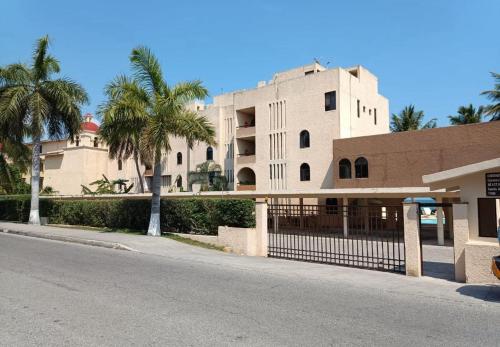 ein Gebäude mit Palmen vor einer Straße in der Unterkunft Hermoso loft frente al mar vista increíble in Cancún