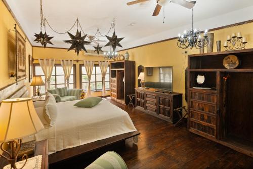 a bedroom with a bed and a tv and chandeliers at Posada de las Flores La Paz in La Paz
