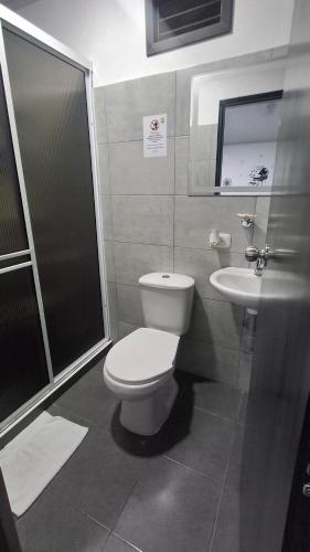 a bathroom with a toilet and a sink at Hotel Antiguo Campestre in Bucaramanga