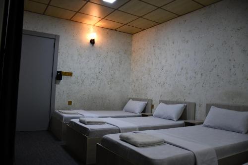 a row of beds in a room at Dolphin Hotel & Hostel in As Sulaymānīyah