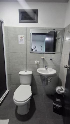a bathroom with a toilet and a sink at Hotel Antiguo Campestre in Bucaramanga