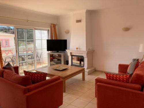 a living room with a tv and a table and chairs at Luxury private property-pool, unique sun roof, free wifi in Budens