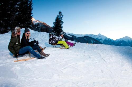 a group of people sitting on a snow covered slope at Ferienwohnung Garber in Zell am Ziller