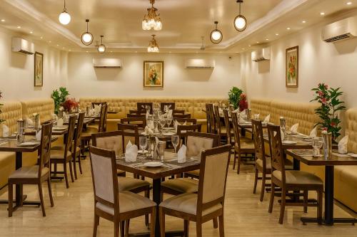 a dining room filled with tables and chairs at IQ Hotels - Luxury Stay Near Ram Mandir in Ayodhya