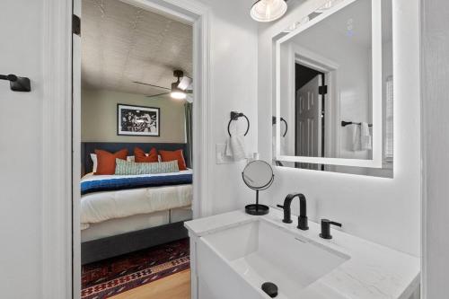 un bagno con lavandino, specchio e letto di New 5 Star Luxury Putting Green Hot Tub EV Fire Pit 5Min From The Masters ad Augusta
