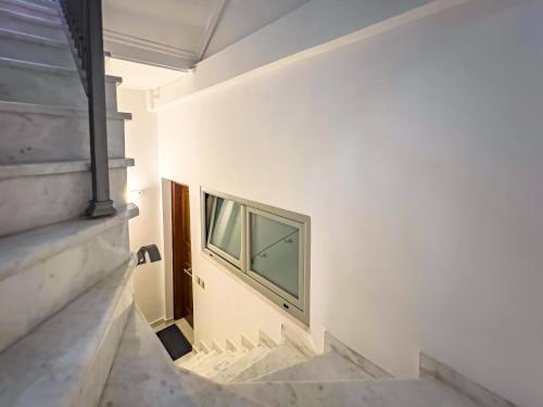 a hallway with a window in a white wall at Filippos Acharnes in Akharnaí