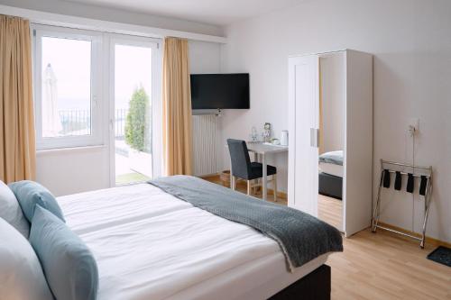 a bedroom with a bed and a desk and a window at Hotel & Restaurant Nollen in Hosenruck