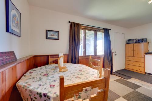 a bedroom with a table and a kitchen with a window at Fish and Hike! Home Base for Kachemak Bay Adventures in Homer
