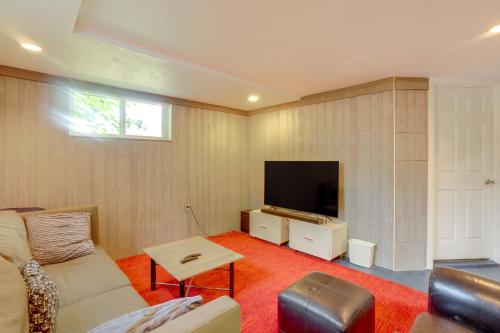 a living room with a couch and a flat screen tv at 12 Mi to Denver Home with Game Room in Wheat Ridge in Wheat Ridge